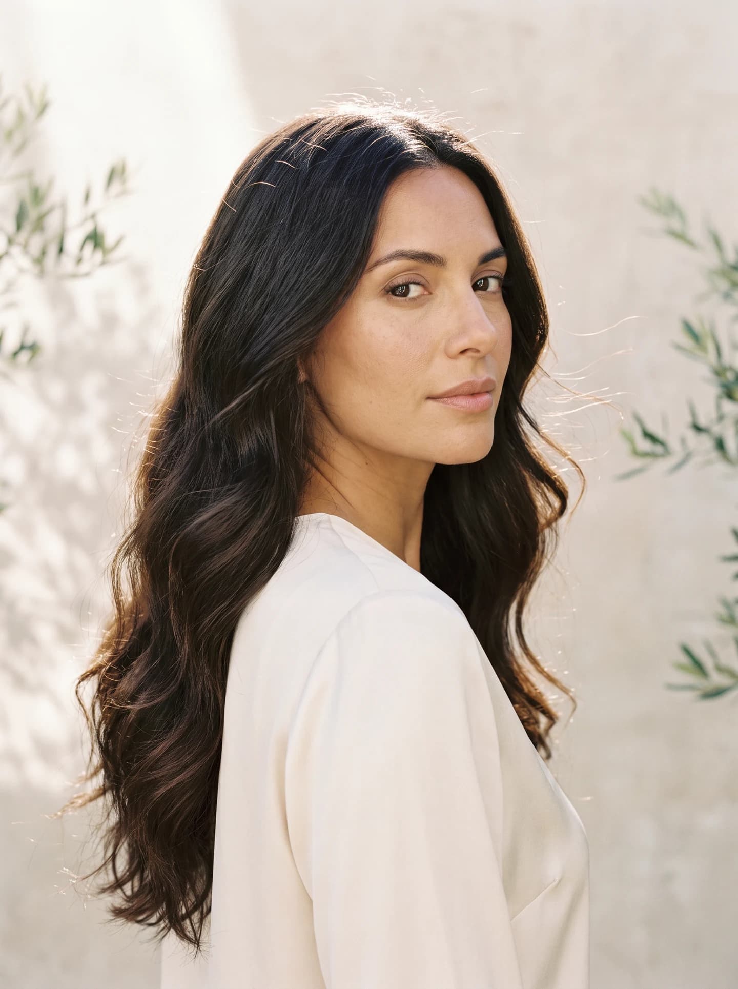 Editorial portrait of a woman with long brunette waves