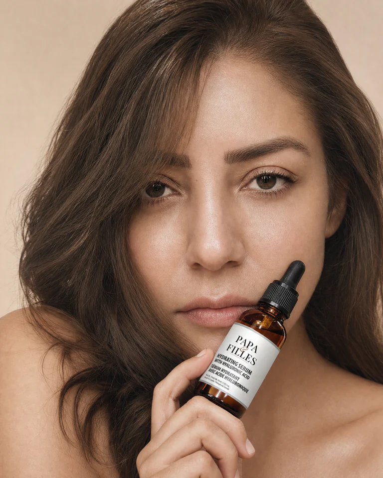Model holding Papa & Filles Hydrating Serum with a glass dropper