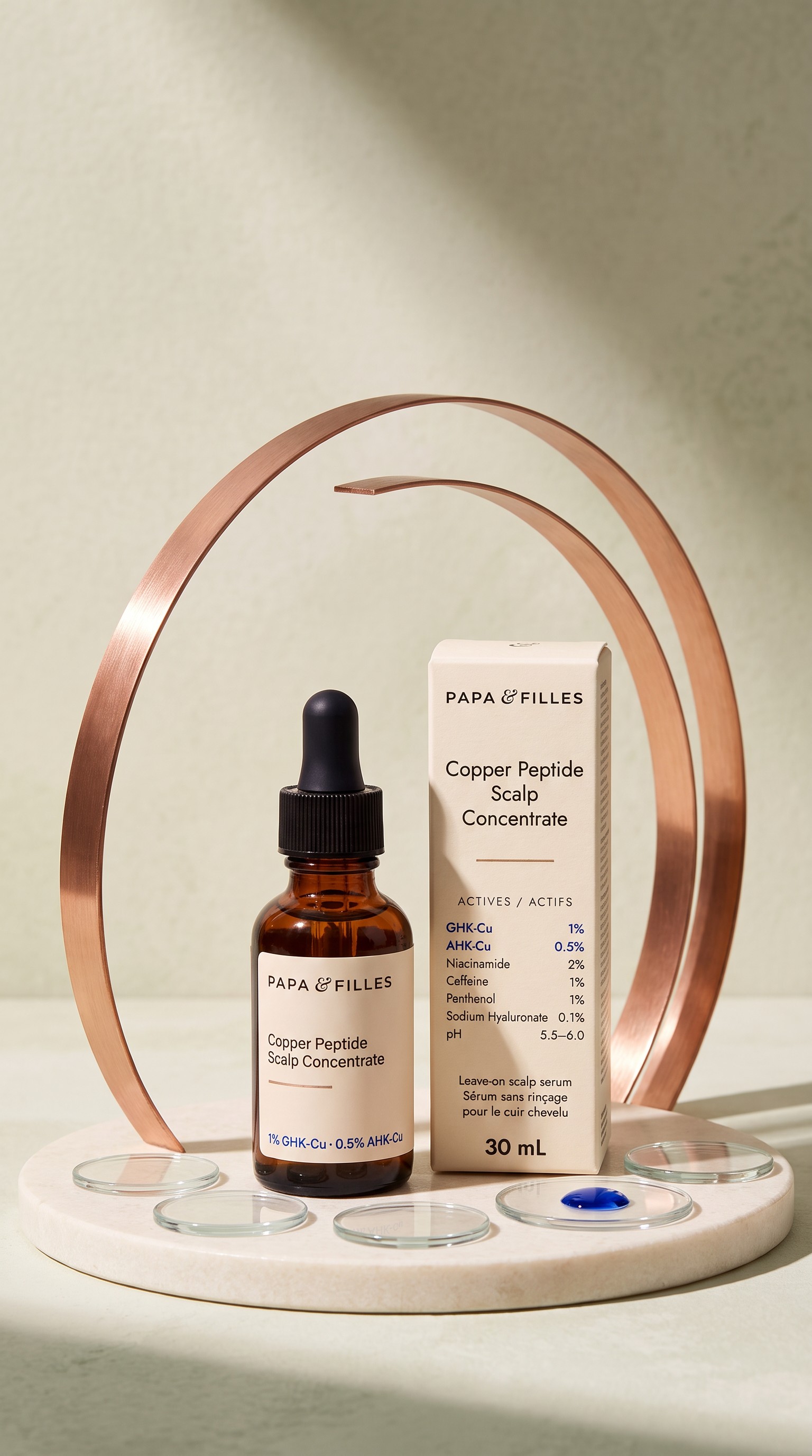 Papa & Filles Dual Peptide Scalp Serum bottle and carton framed by a copper ring